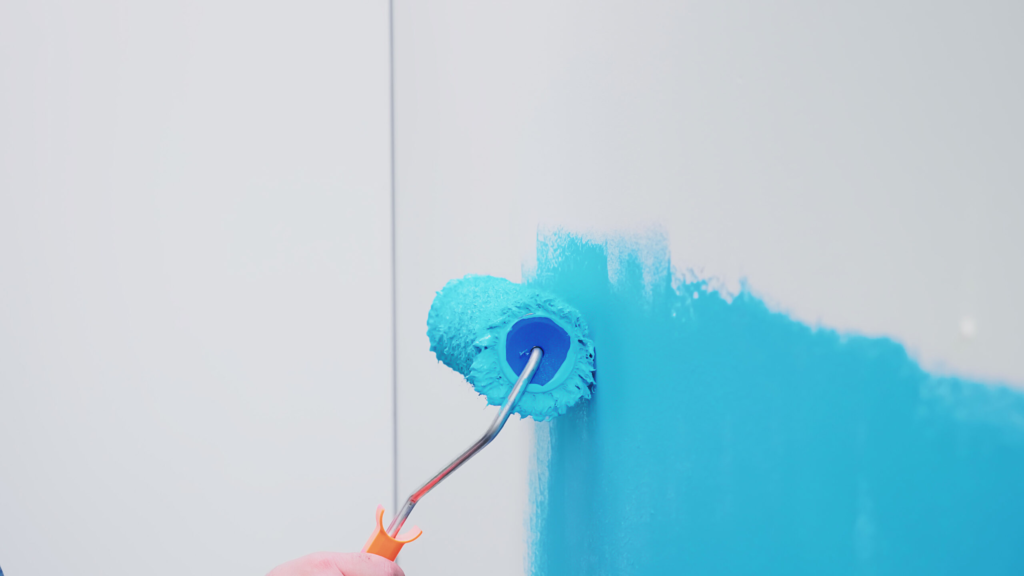 roller brush wall with blue paint apartment redecoration home construction while renovating improving repair decorating.webp